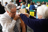 Dr David Butler&shy;Jones, administrateur en chef de la sant&eacute; publique du Canada, re&ccedil;oit son vaccin contre le grippe H1N1 de Barbara Ellis, une infirmi&egrave;re en sant&eacute; publique &agrave; Ottawa.